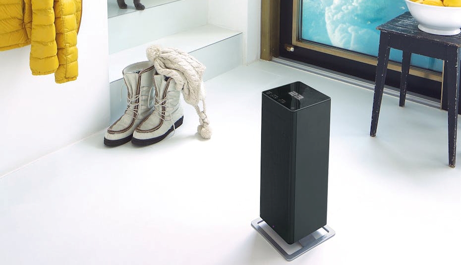 Termowentylator Anna big stoi na białej podłodze. Na schodach stoi kot. Za oknem zimowy widok.