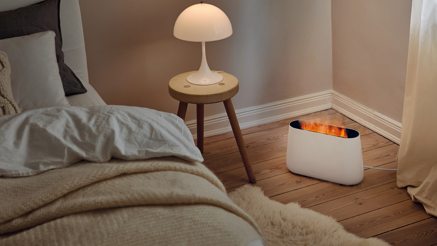 Nawilżacz powietrza Ben w kolorze białym od Stadler Form na komodzie w ciemnym pomieszczeniu