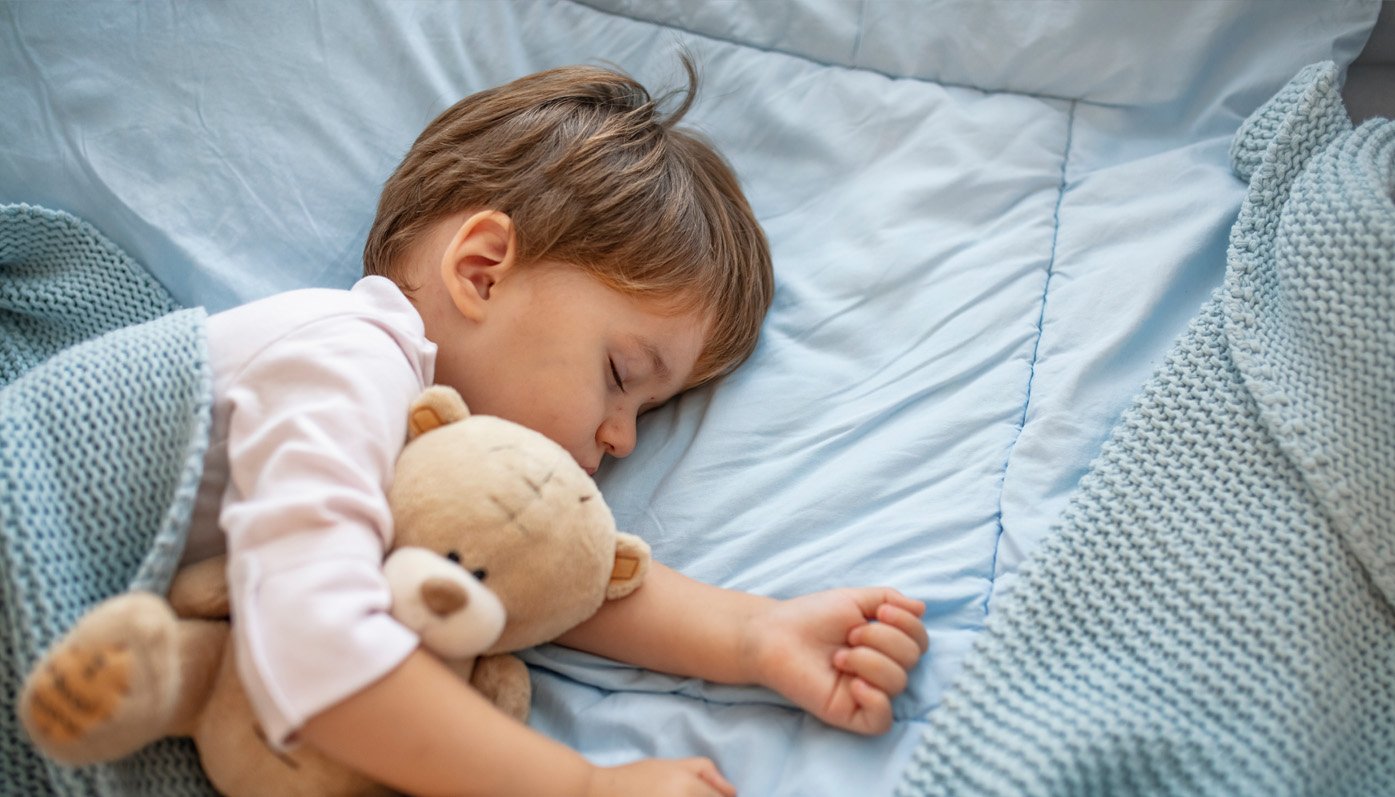 Idealny do sypialni dziecko śpi w niebieskiej pościeli