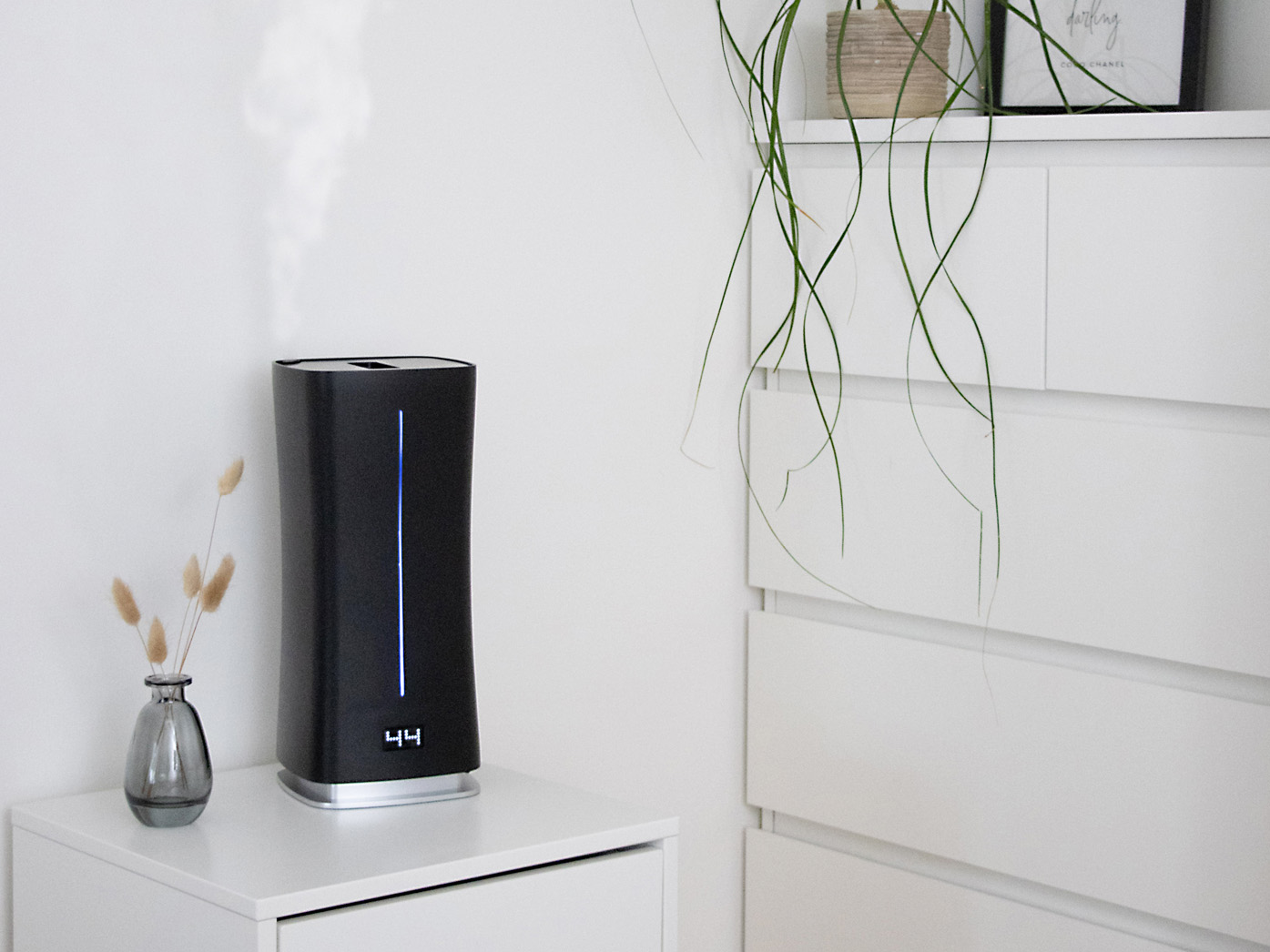 Tryb automatyczny Eva little w czarnym kolorze stoi w na białej szafce nocnej