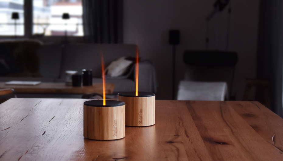 Dwa aromatyzery Nora z efektem płomienia stoją na drewnianym stole