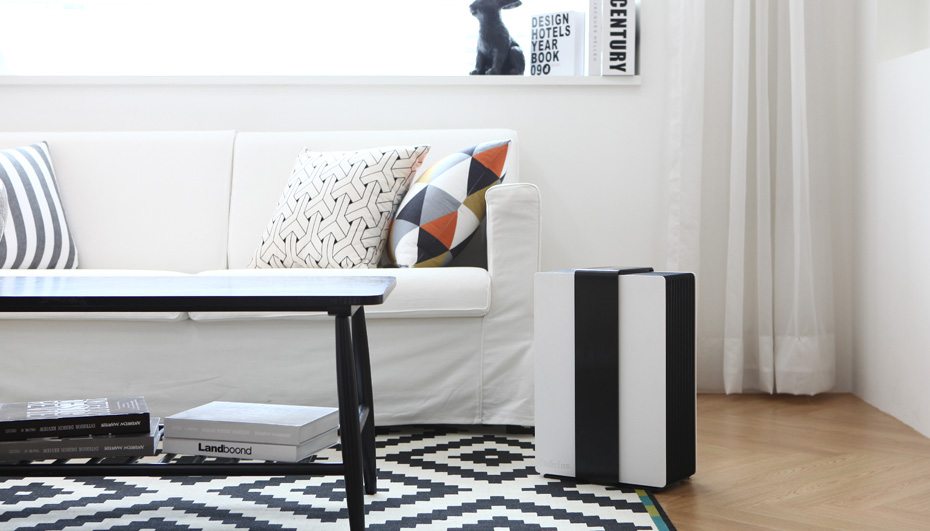 Nawilżacz z funkcją oczyszczania powietrza Robert stoi w jasnym salonie obok białej sofy