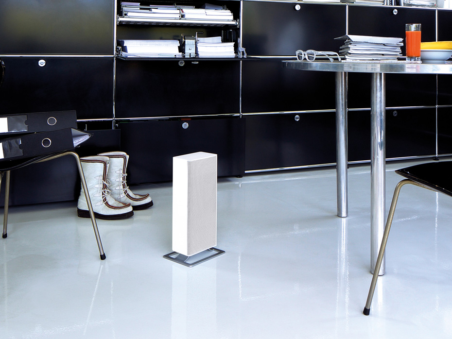 Termowentylator Stadler Form Anna stoi na podłodze w biało-czarnej przestrzeni biurowej